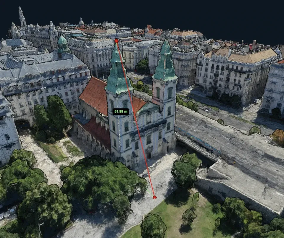Dense colour point cloud of a city block viewed in 3D, zoomed in enough that individual points are visible on roofs and trees